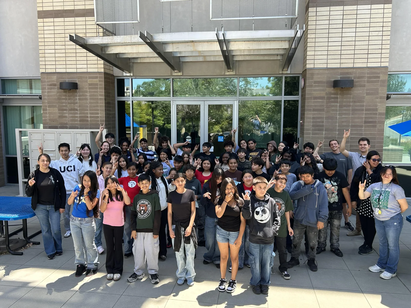 Visiting Jones Elementary School students and their hosts gathered outside a building on the UCI campus.