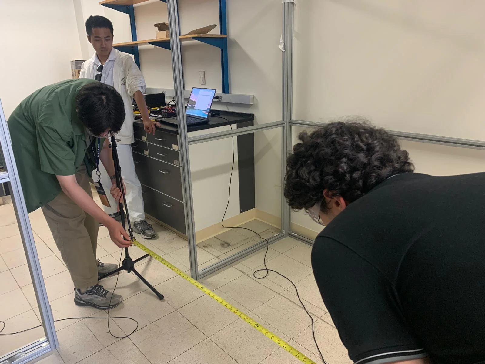 Students measuring the microphone position beside the propeller test stand.