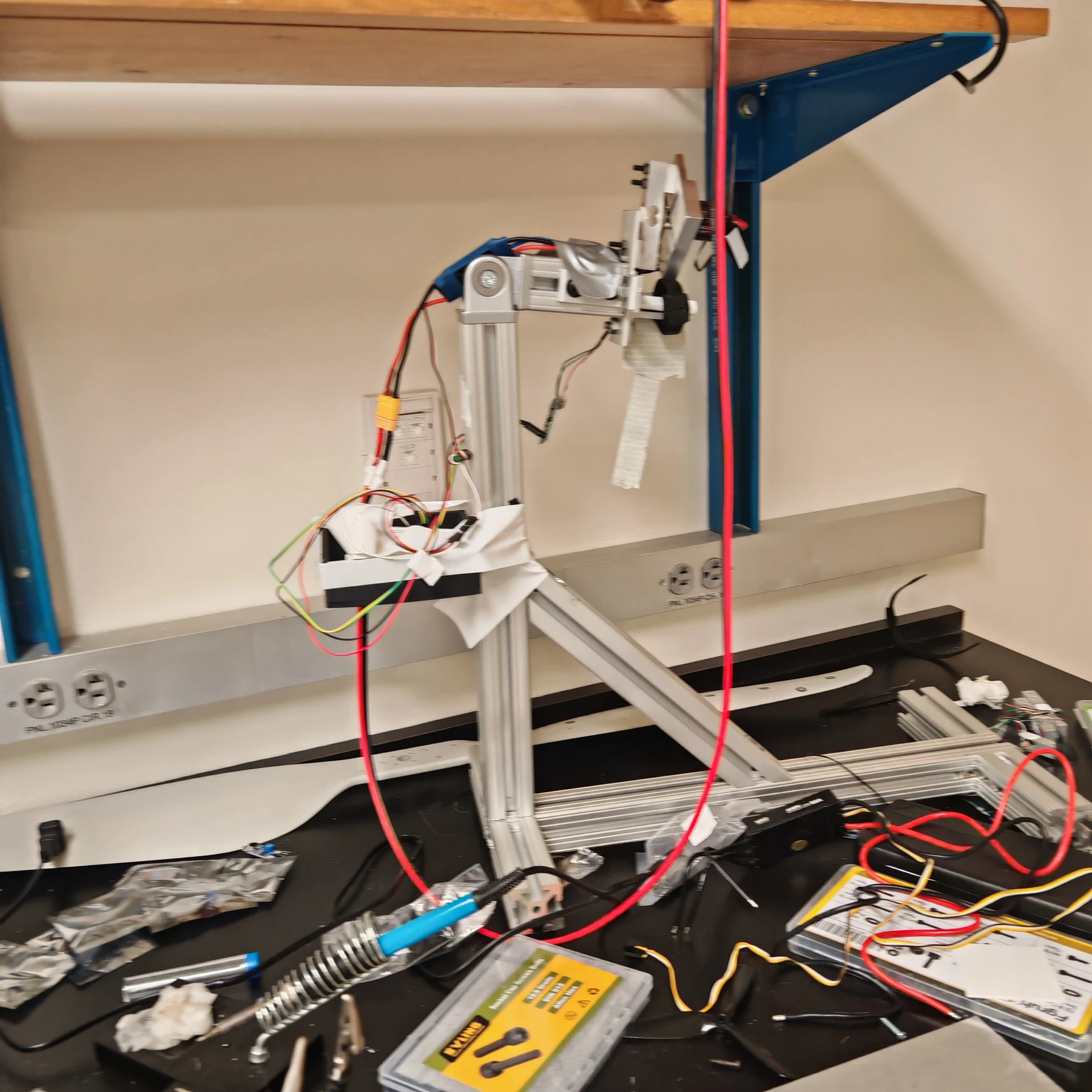 The first mini test stand on a lab bench, with its aluminum frame, propeller mount, and breadboard wiring
